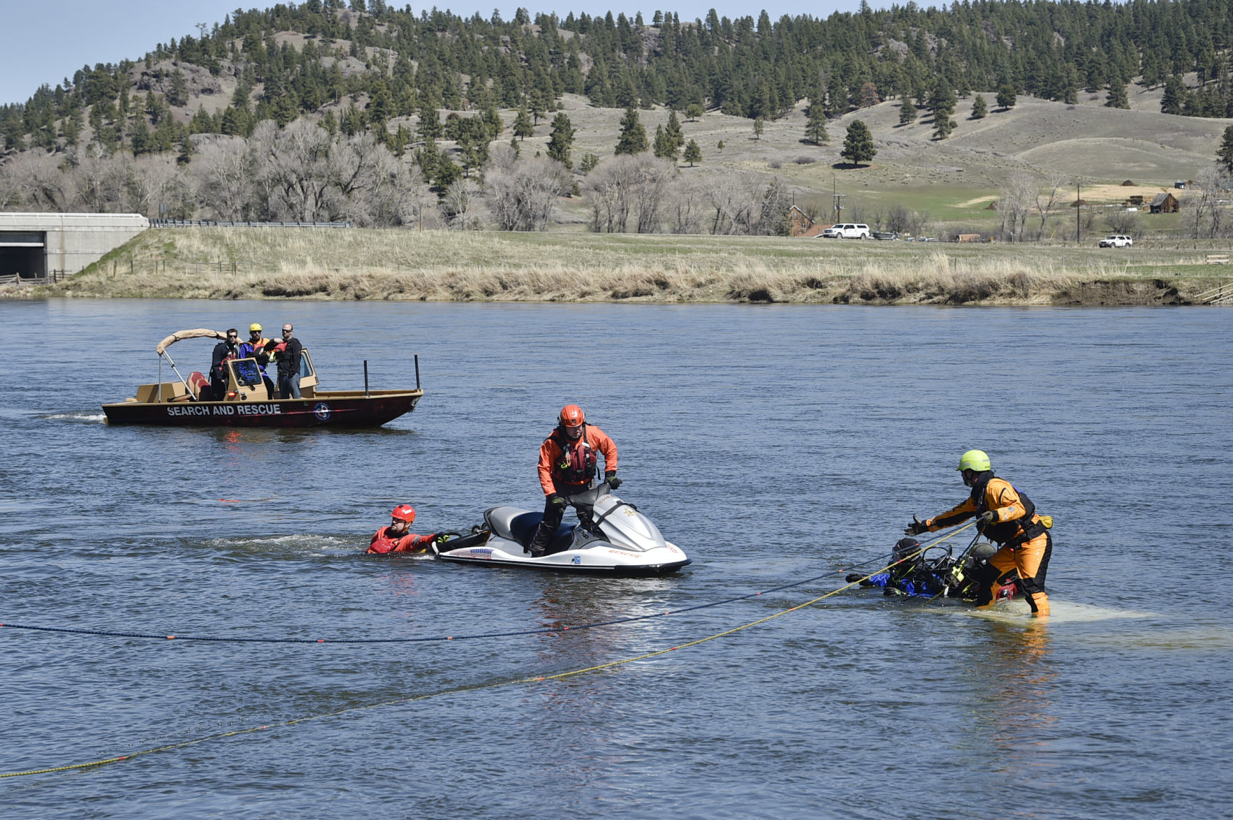 Search and rescue divers work to hook the submerged truck